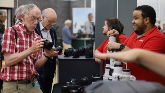 Customer locking at a camera with support from a Canon employee